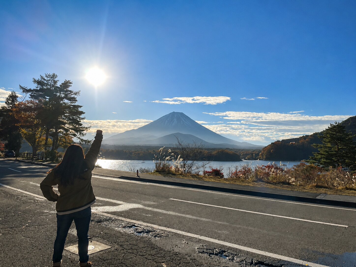 湖越しの富士山に向かって手を上げるキャンプ旅の一場面